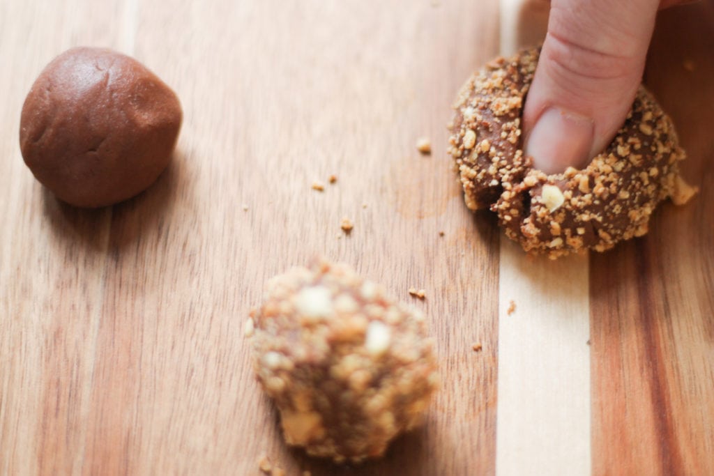 Thumbprint cookies on cutting board getting indent for filling