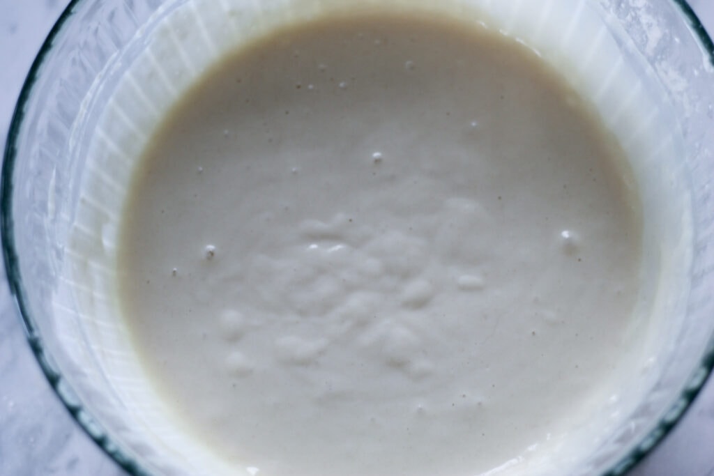 Glass bowl with pancake batter fully mixed.
