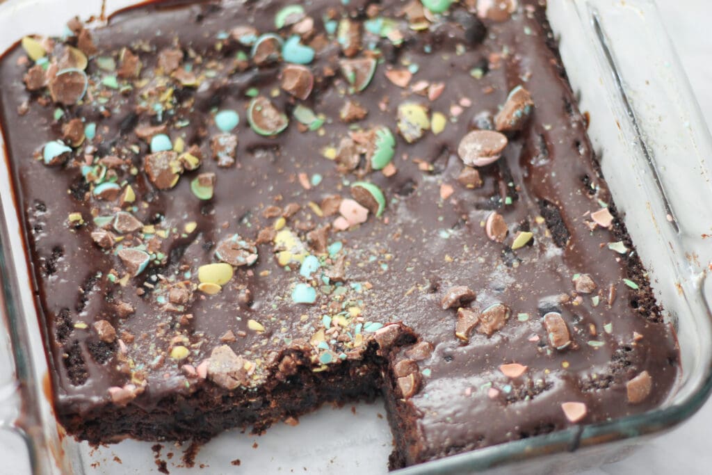 Brownies in baking dish with two squares cut.