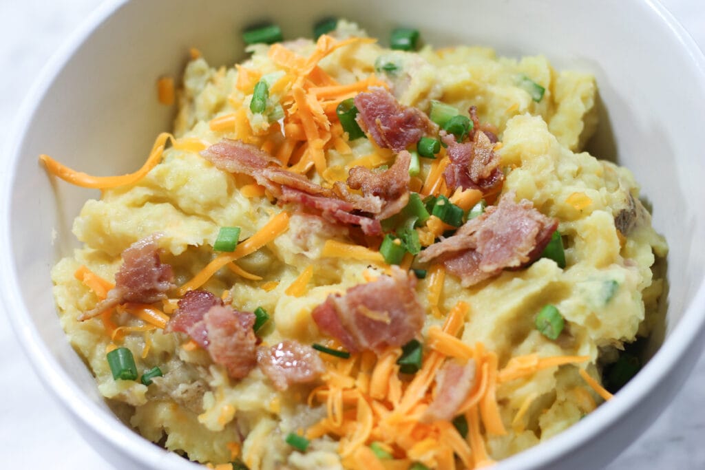 White ceramic bowl with loaded mashed potatoes.